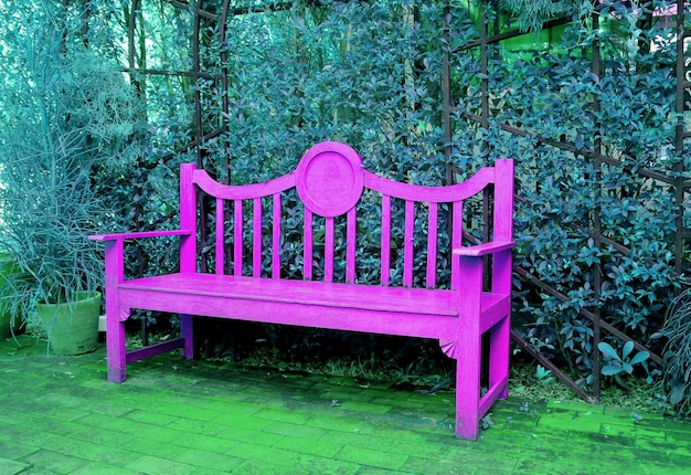 Levendige roze houten bank in pop-artstijl in een turkooisblauwe tuin