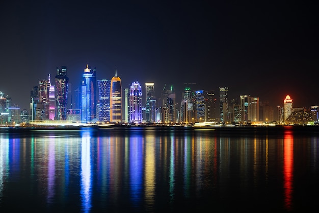 Foto levendige skyline van doha 's nachts gezien vanaf de andere kant van de baai van de hoofdstad' s nachts.