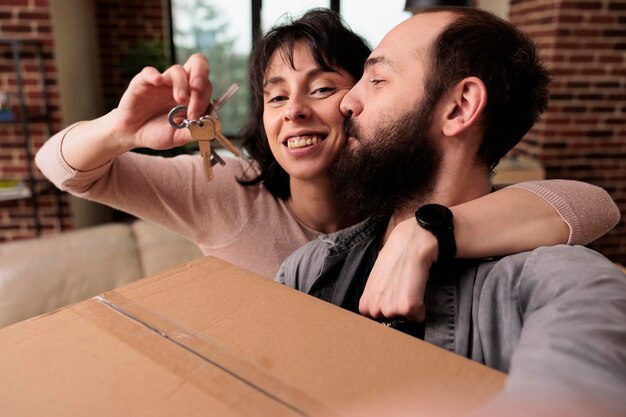 Levenspartners die samen het eerste huis kopen en sleutels hebben, huiseigenaren zijn om een nieuw begin te maken. Relatiegebeurtenis vieren met verhuizing van het huishouden, intrekken.