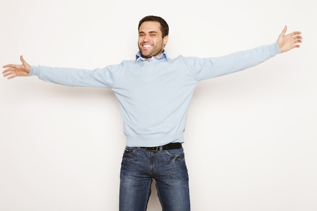 Levensstijl en mensen concept: casual jonge man in shirt met beide handen in de lucht. Winnaar en blij.