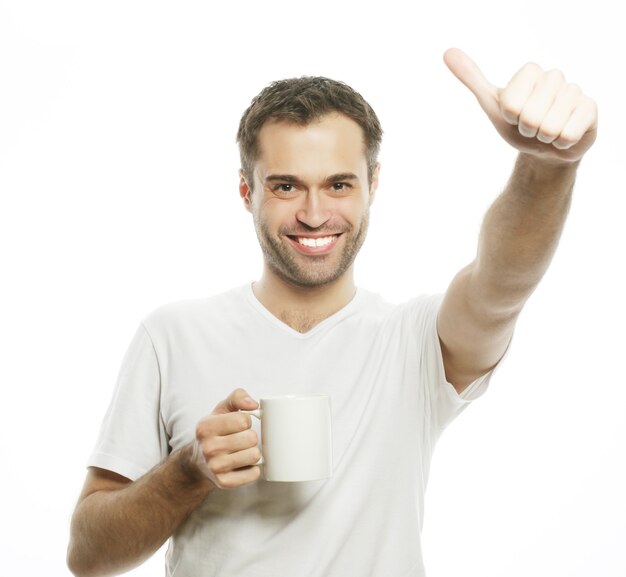 Levensstijl, eten en mensen concept: casual jonge man met witte kop met koffie of thee.