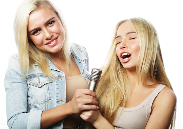 levensstijl geluk emotioneel en mensen concept twee jonge meisjes zingen op witte achtergrond
