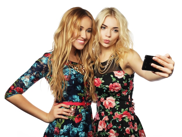 Levensstijl, geluk, emotioneel en mensenconcept: twee jonge vrouwen die selfie met mobiele telefoon nemen