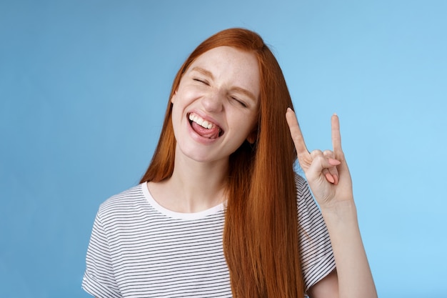 Levensstijl. Gelukkig vrolijk onbezorgd koelende roodharige tienermeisje met plezier stok tong ogen sluiten dansen vreugdevol rock-n-roll heavy metal teken genieten van feest amusant festival muziek prestaties.