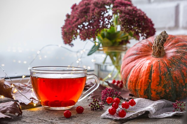 Levensstijl van comfort in de herfst. Een salontafel met een kopje thee bij het raam met rai