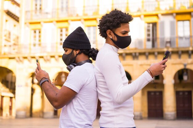 Levensstijl, vrienden schrijven een bericht aan de telefoon met een masker.