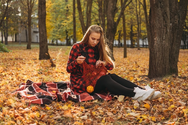 Levensstijlportret van een gelukkige vrouw in het herfstpark, mooi meisje op de natuurpicknick, ontspannen op de camping