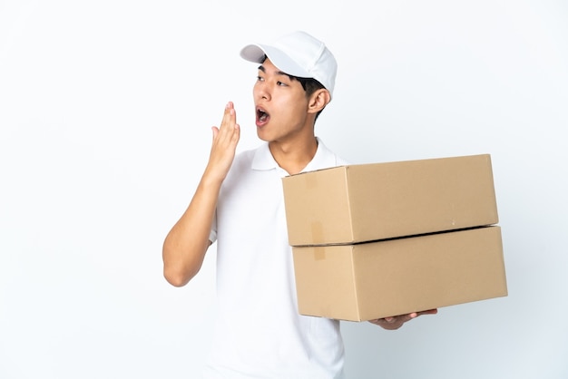 Levering Chinese man geïsoleerd op een witte muur geeuwen en wijd open mond bedekken met de hand