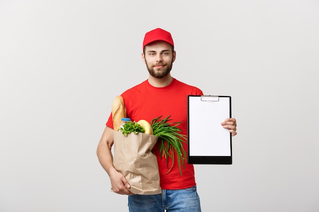 Levering concept: knappe blanke bezorger koerier man in rood uniform met boodschappen doos