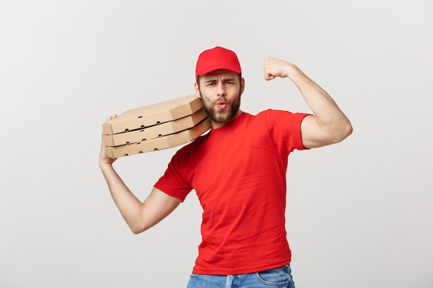 Levering concept - portret van sterke knappe bezorger buigen zijn spier en houden pizzadoos