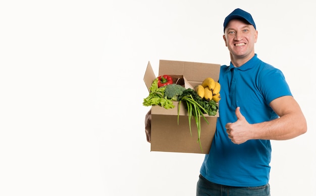 Foto levering man poseren met kruidenier doos en duimen omhoog