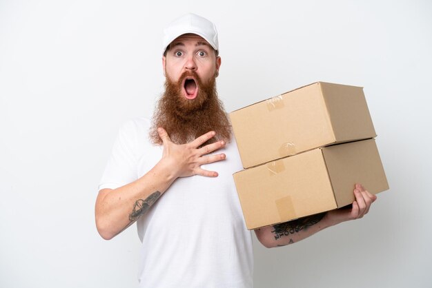 Levering roodachtige man geïsoleerd op een witte achtergrond verrast en geschokt terwijl hij naar rechts kijkt