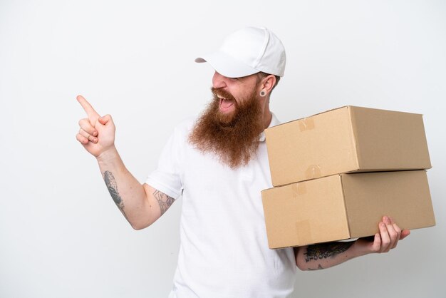 Levering roodachtige man geïsoleerd op witte achtergrond wijzende vinger naar de zijkant en het presenteren van een product