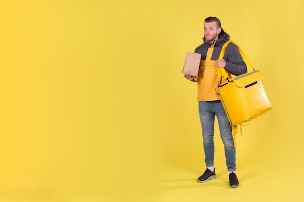 Foto levering van voedsel jonge man in een gele jas