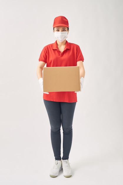 Leveringsvrouwen met medisch masker en rubberen handschoenen met kartonnen dozen.