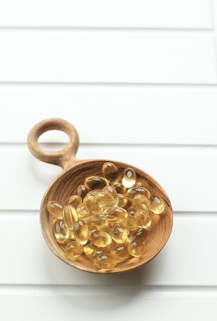 Levertraan Omega 3 Gelcapsules op houten lepel