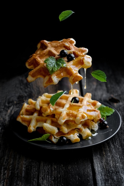 Levitating homemade waffles with honey on plate