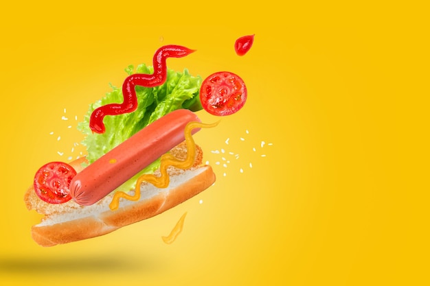 Foto hot dog levitante su sfondo giallo ingredienti hotdog volanti