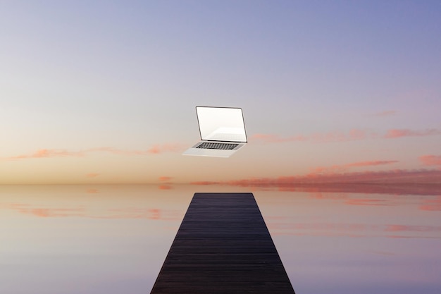 Foto laptop levitante all'estremità del molo di legno al tramonto