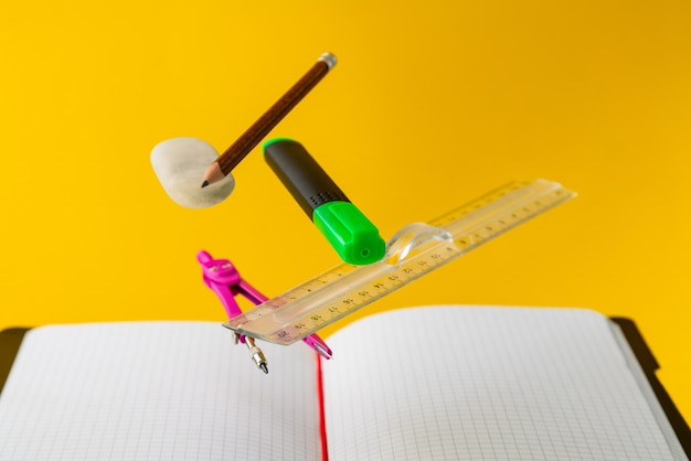 Levitating school supplies for math on yellow background. education and creativity