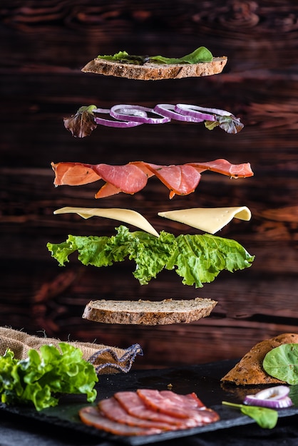 Levitation of sandwich ingredients on the wood background