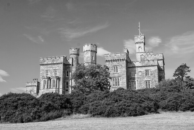 자연 경관에 푸른 나무가 있는 스토노웨이 영국 성(Stornoway United Kingdom Castle)의 푸른 하늘에 있는 루이스 성(Lews Castle) 빅토리아 스타일 건축 및 디자인 랜드마크 및 명소 여름 휴가 및 방랑벽