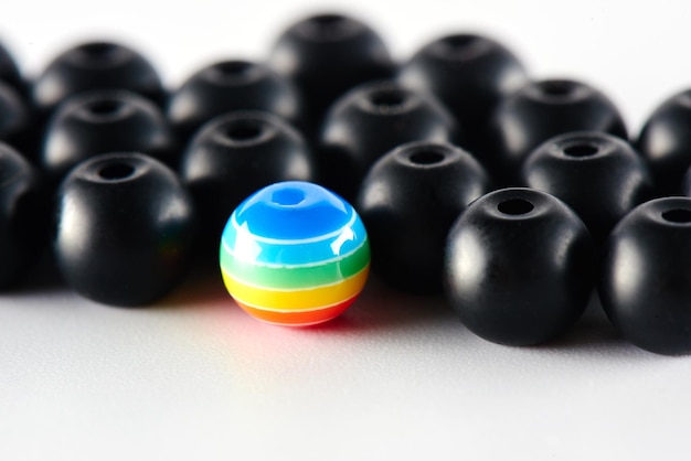 Photo lgbt concept. many black balls and one painted in the colors of the rainbow.