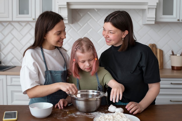 Foto coppia lgbt che trascorre del tempo insieme alla figlia in cucina