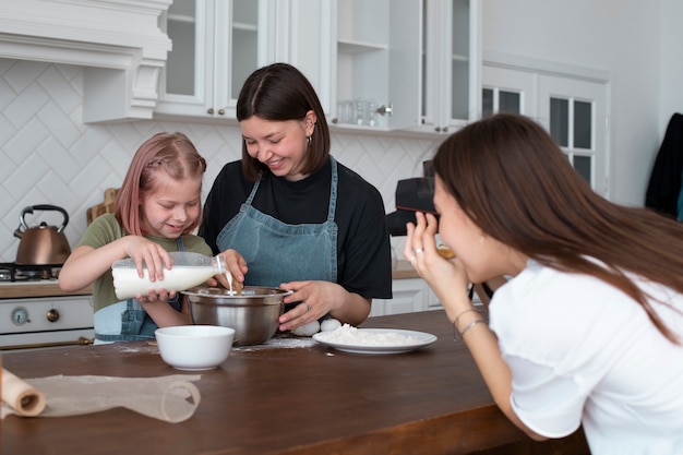 Foto coppia lgbt che trascorre del tempo insieme alla figlia in cucina