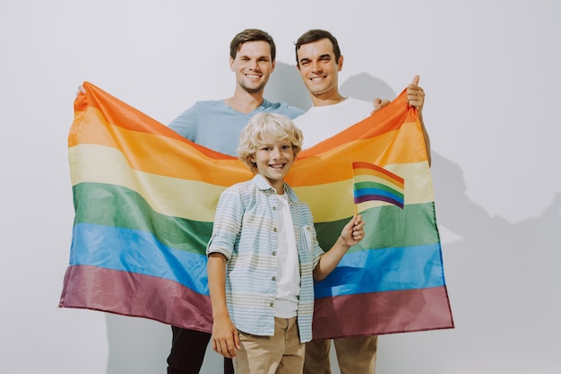 Lgbt-familie homopaar met geadopteerde zoon Homoseksuele ouders met hun kind dat plezier heeft thuis