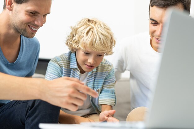 Lgbt family, gay couple with adopted son - Homosexual parents with their kid having fun at home