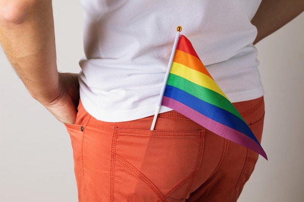 LGBT flag in the back pocket of coral colored jeans closeup