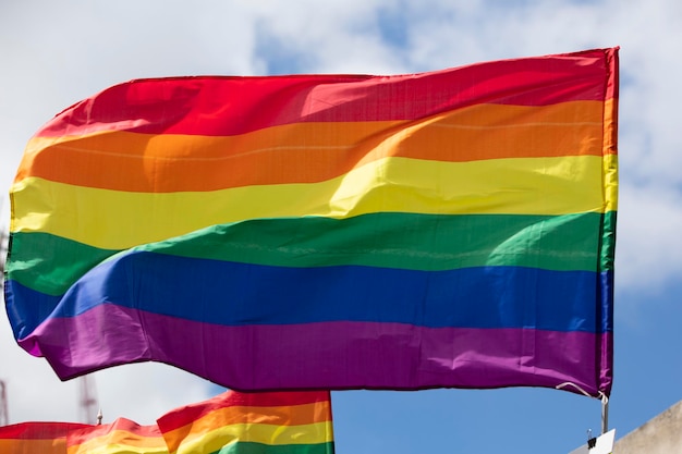 A lgbt gay pride rainbow flag being waved at a pride community celebration event