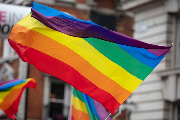 A lgbt gay pride rainbow flag being waved at a pride community celebration event