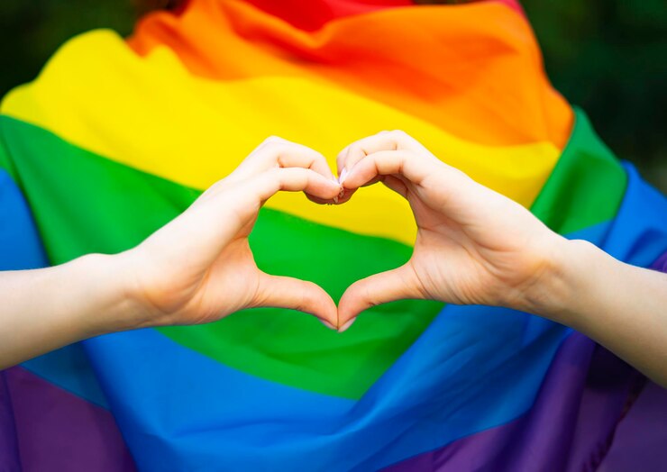 Lgbt 소녀 레즈비언 여자는 배경에 그녀의 손가락 손으로 하트 모양의 기호를 보여줍니다 ...