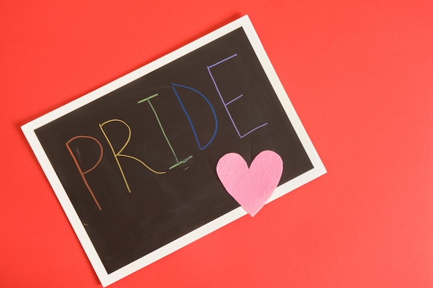 Photo lgbt pride month in june inscription pride on black board on lgbt flage