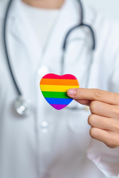 Photo lgbt pride month or lgbtq or lgbtqia and health concept doctor with rainbow and colorful heart shape with for lesbian gay bisexual transgender queer and pansexual community