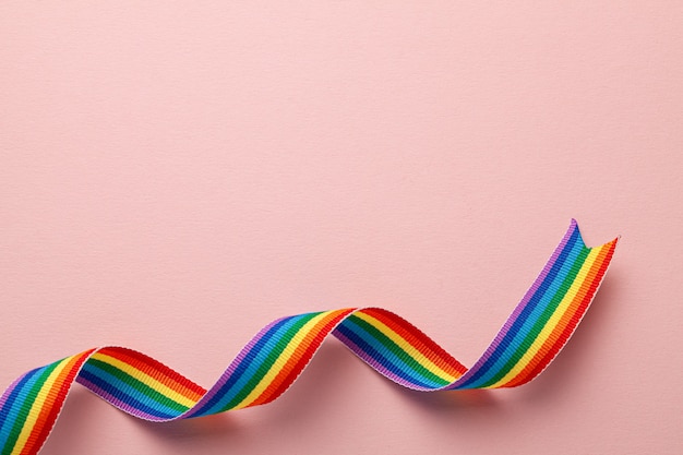 LGBT regenboog lint trots symbool. Roze achtergrond. Ruimte voor tekst kopiëren.