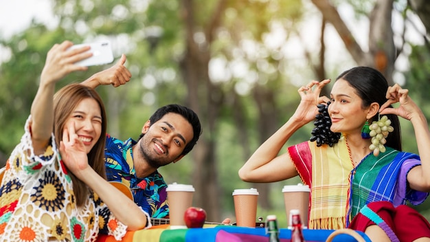 Picnic di amici lgbtq giovani amici felici che fanno un picnic nel parco cittadino persone che escono sorridendo