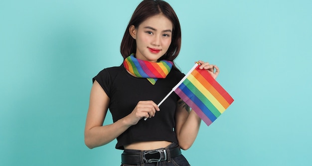 LGBTQ girl and pride flag. Sexy Lesbian girl and LGBTQ flag standing. blue green background. 