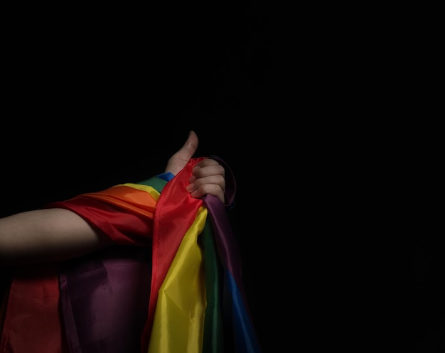 Lgbtq pride flag on black background lgbt rainbow flag in gay\
hand