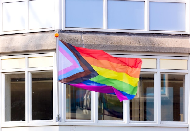 LGBTQ regenboogvlag wordt gevlogen op de gevel van het gebouw Stadsstraat Gelijke rechten Amsterdam Holland Nederland Europa