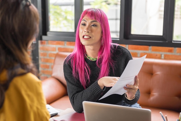 Foto uomo transgender lgbtq bello specialista autentico con i capelli rosa e trans non binario che lavora insieme lavorare design in un posto di lavoro creativo colleghi di lavoro di squadra parità di genere