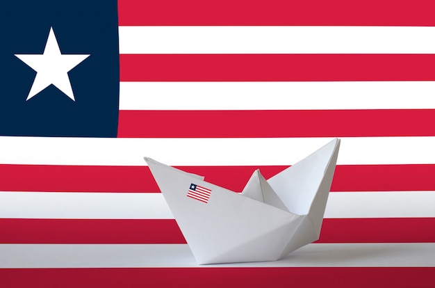 Liberia flag depicted on paper origami ship closeup. Handmade arts concept