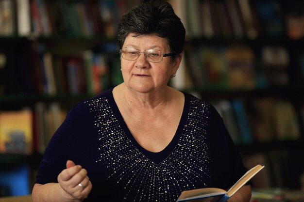 The librarian keep the book in her hands against the surface of the bookshelves