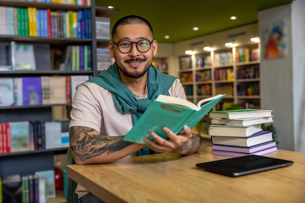 図書館で。図書館で本を読むアジア人男性