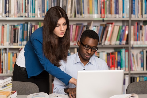 In The Library  Handsome Two College Students With Laptop And Books Working In A High School  University Library  Shallow Depth Of Field