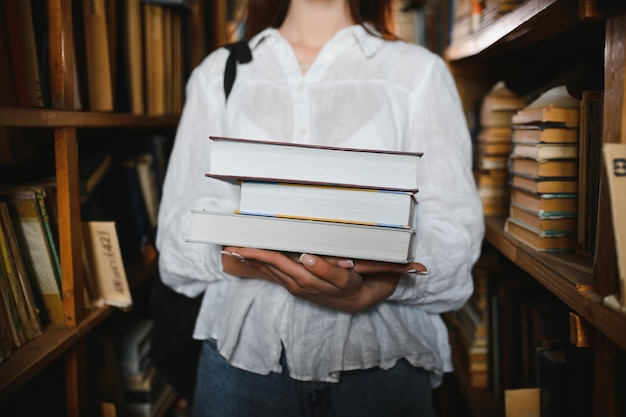 In the library pretty female student with books working in a high school library