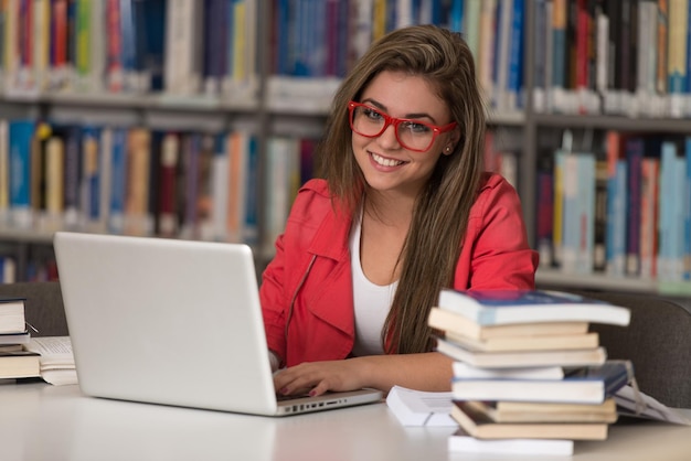 In The Library  Pretty Female Student With Laptop And Books Working In A High School Or University Library  Shallow Depth Of Field