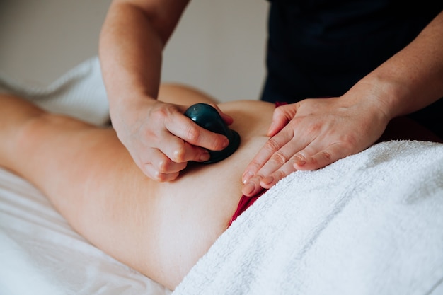 Lichaamsmassagepot op het been van de persoon Massagetherapeut die massage doet met een vacuümmassagepot